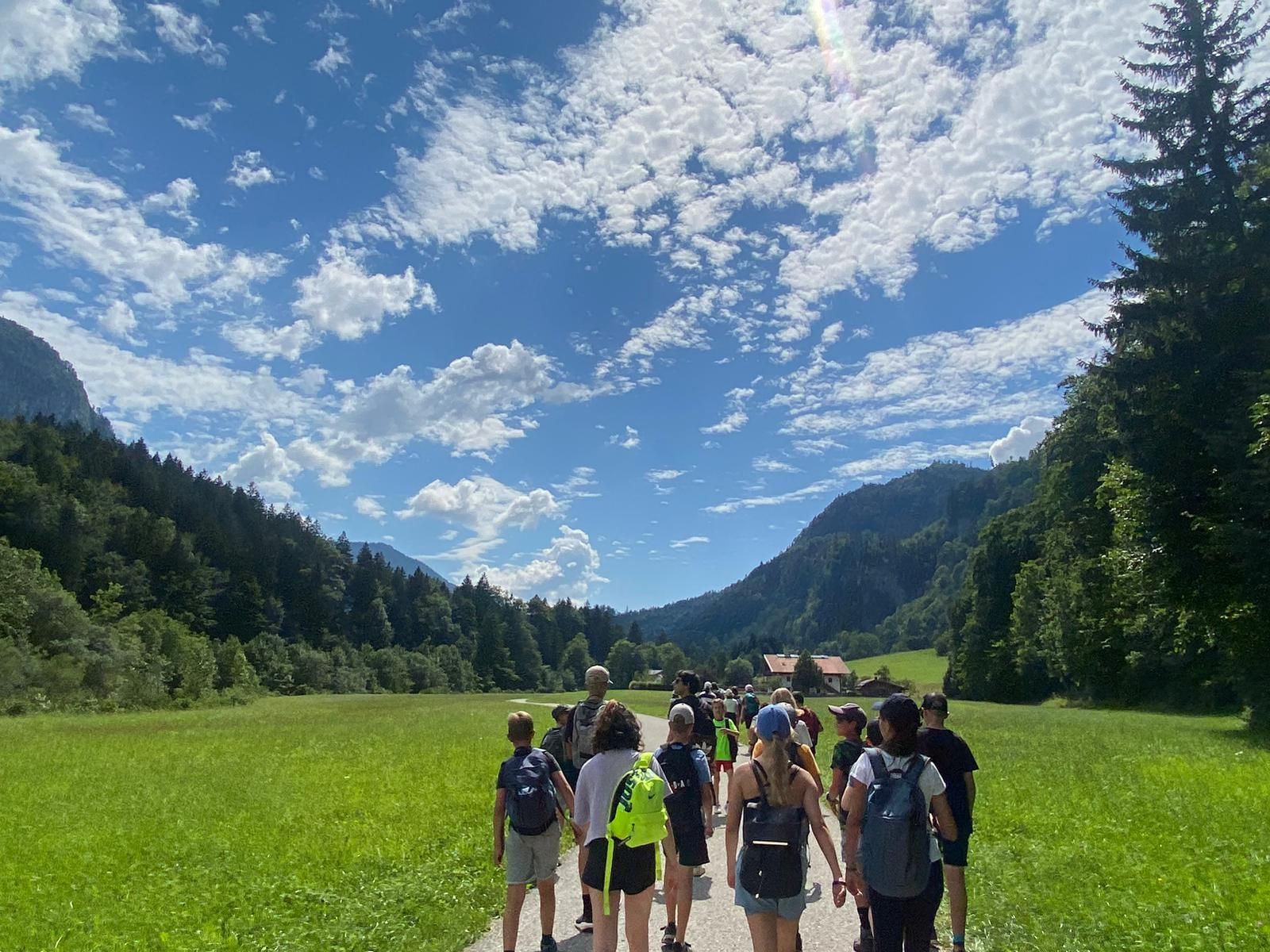 Eine Gruppe von Leuten geht einen Weg auf einem Feld entlang.