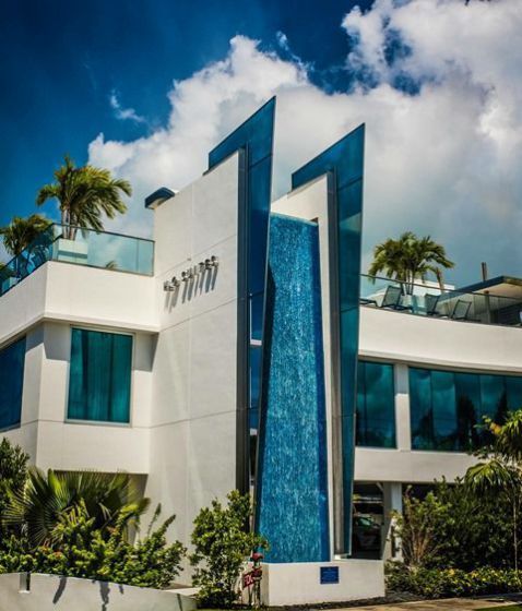 A large white building with a blue waterfall in front of it