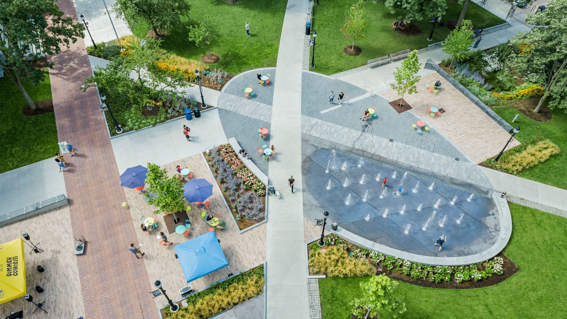 An aerial view of a park with a fountain and people.