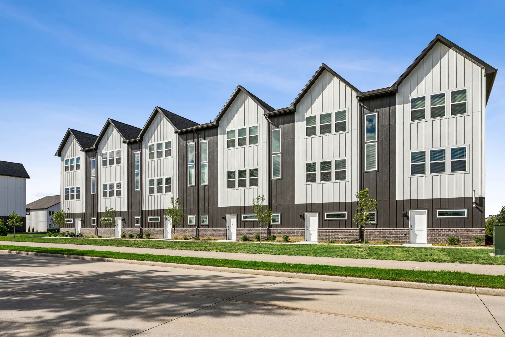 Balcony view of a residential apartment complex with new townhomes and a curved street below