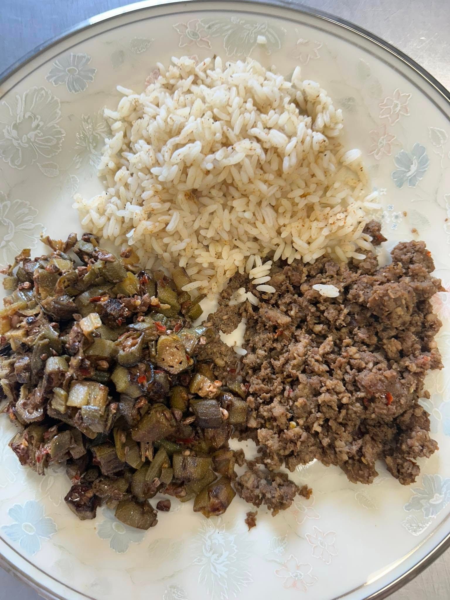 Plate with white rice, minced meat, and sautéed vegetables arranged in separate sections