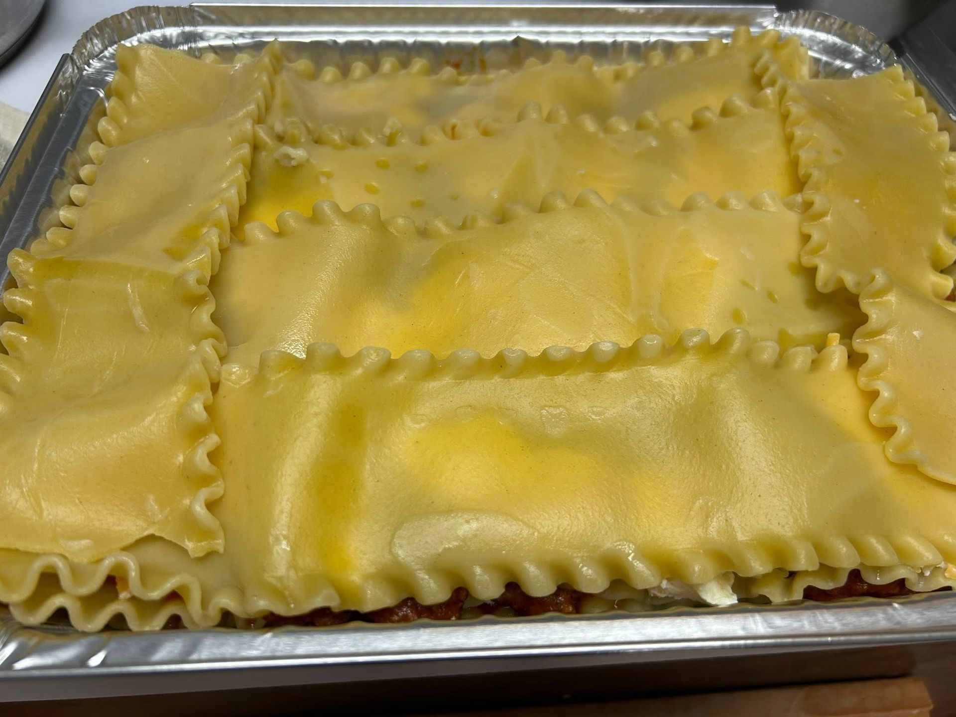 Tray of uncooked cheese ravioli in a metal pan
