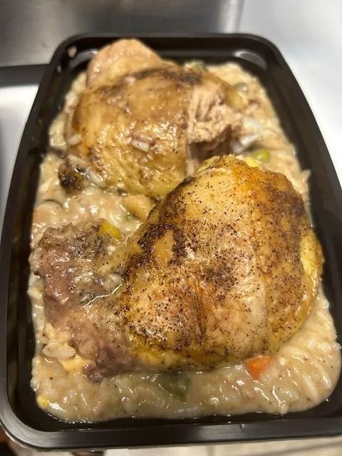 Tray of baked chicken in creamy sauce with vegetables