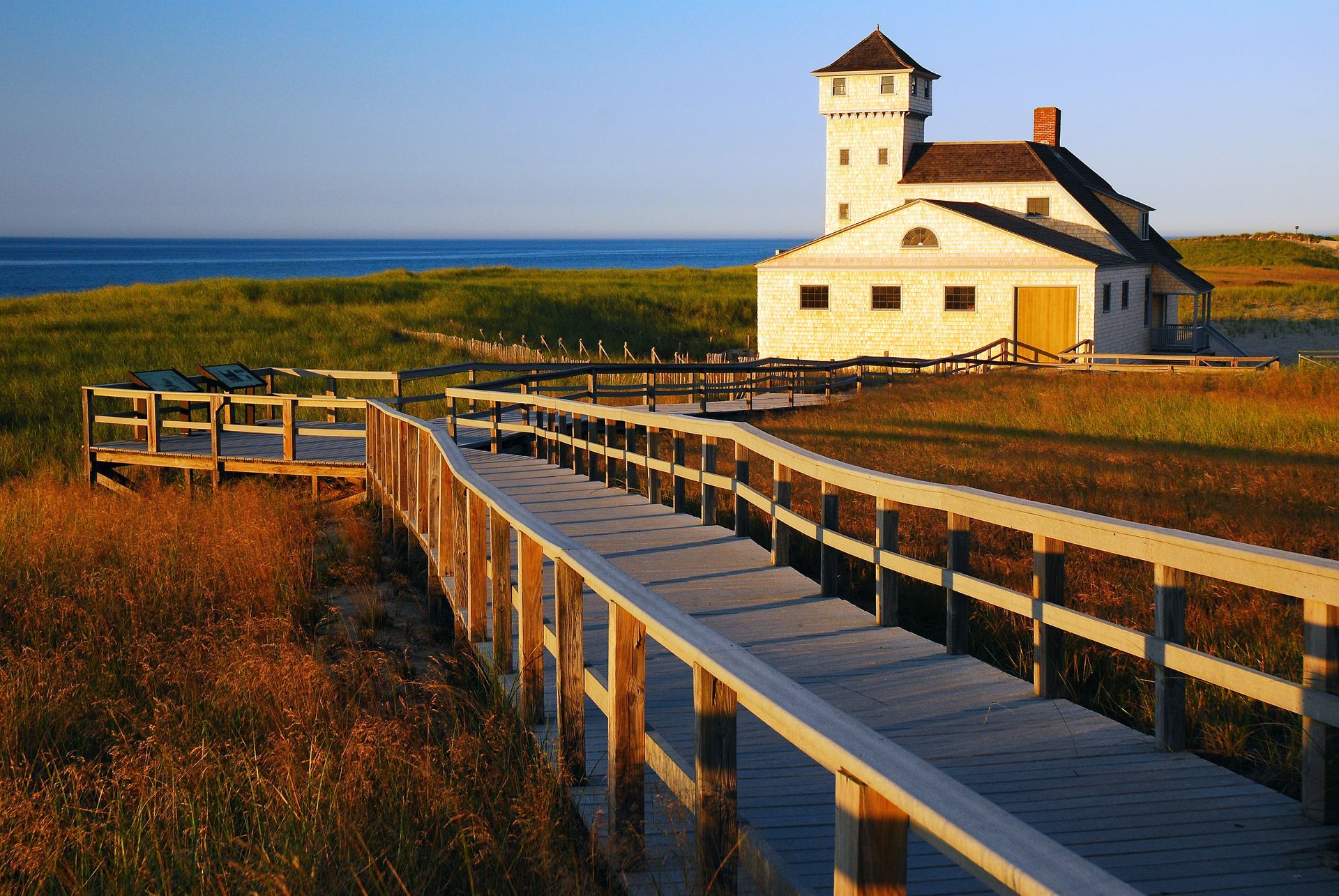 A white house with a wooden walkway leading to it
