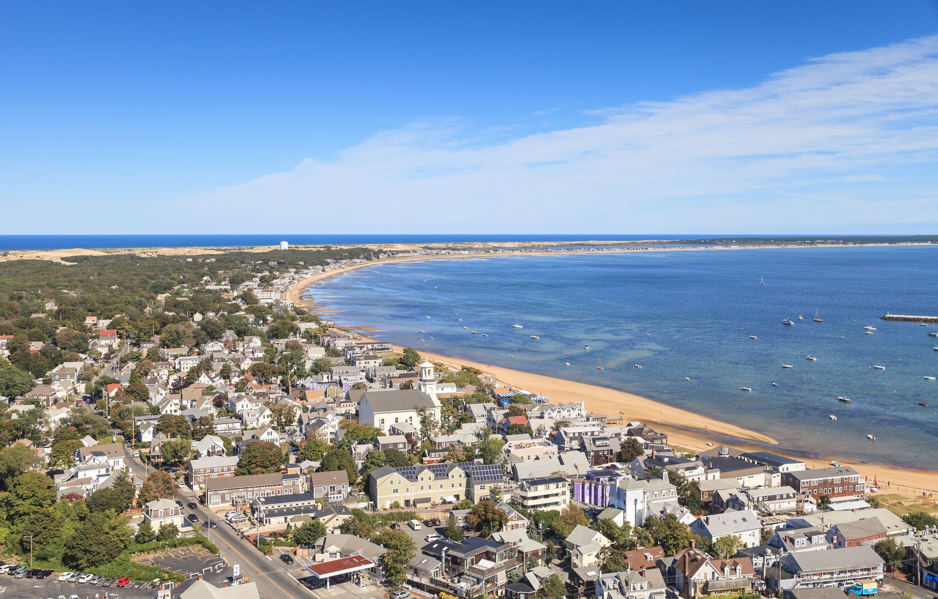 An aerial view of a small town next to a large body of water.
