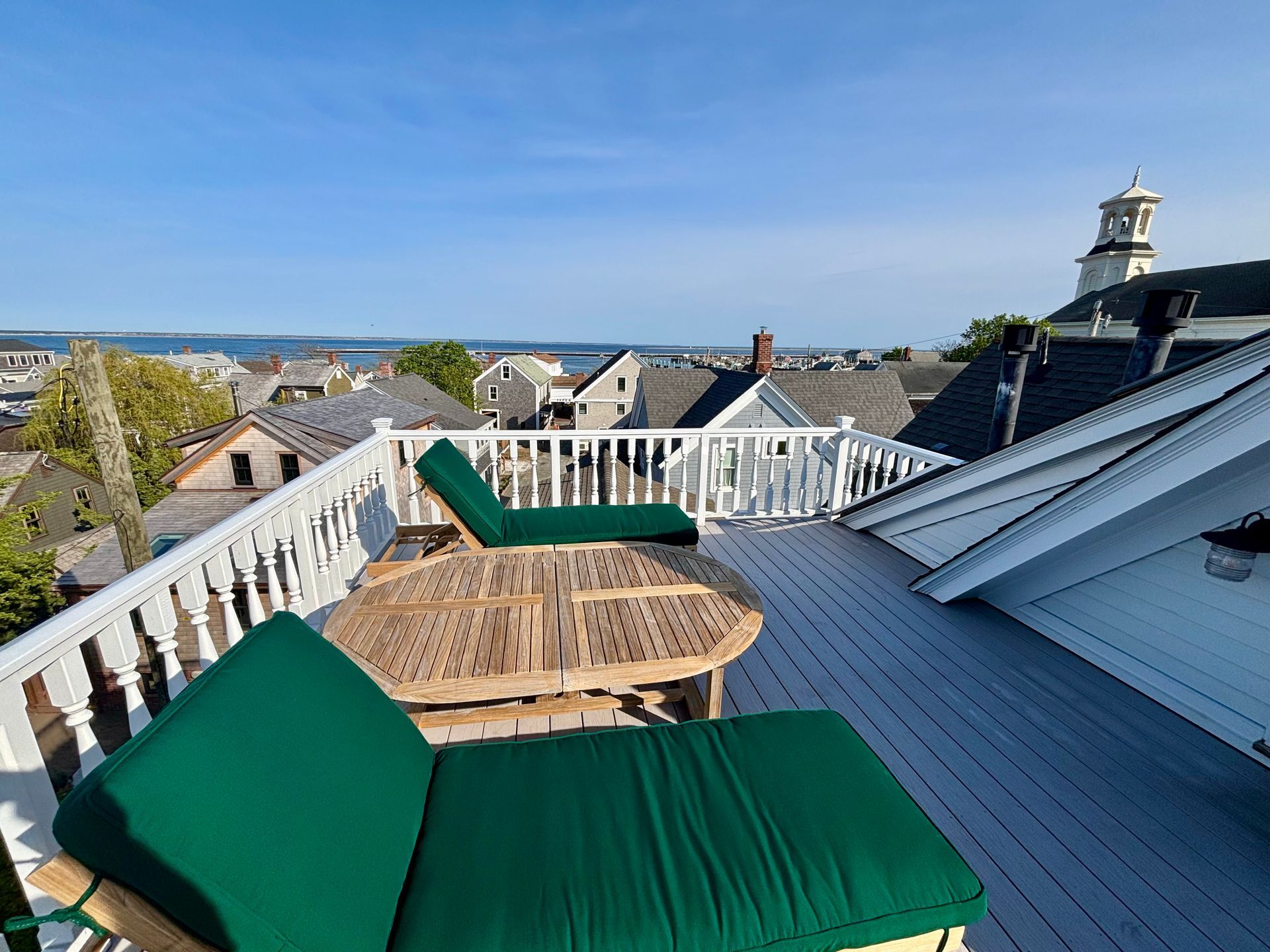 Exterior picture of private roof deck, two lounge chairs, table and bay views
