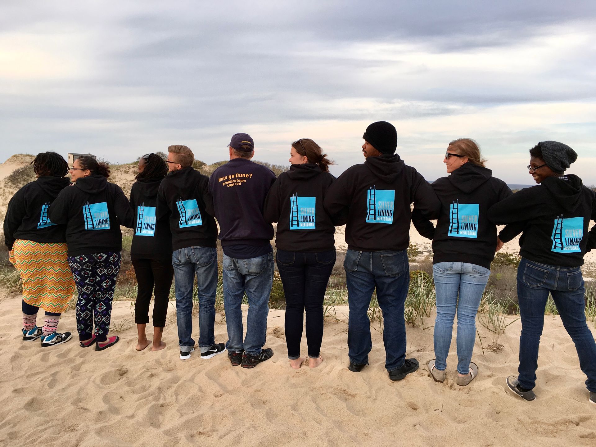 Youth and staff of Silver Lining Mentoring on the dunes of Cape Cod wearing SLM sweat shirts.