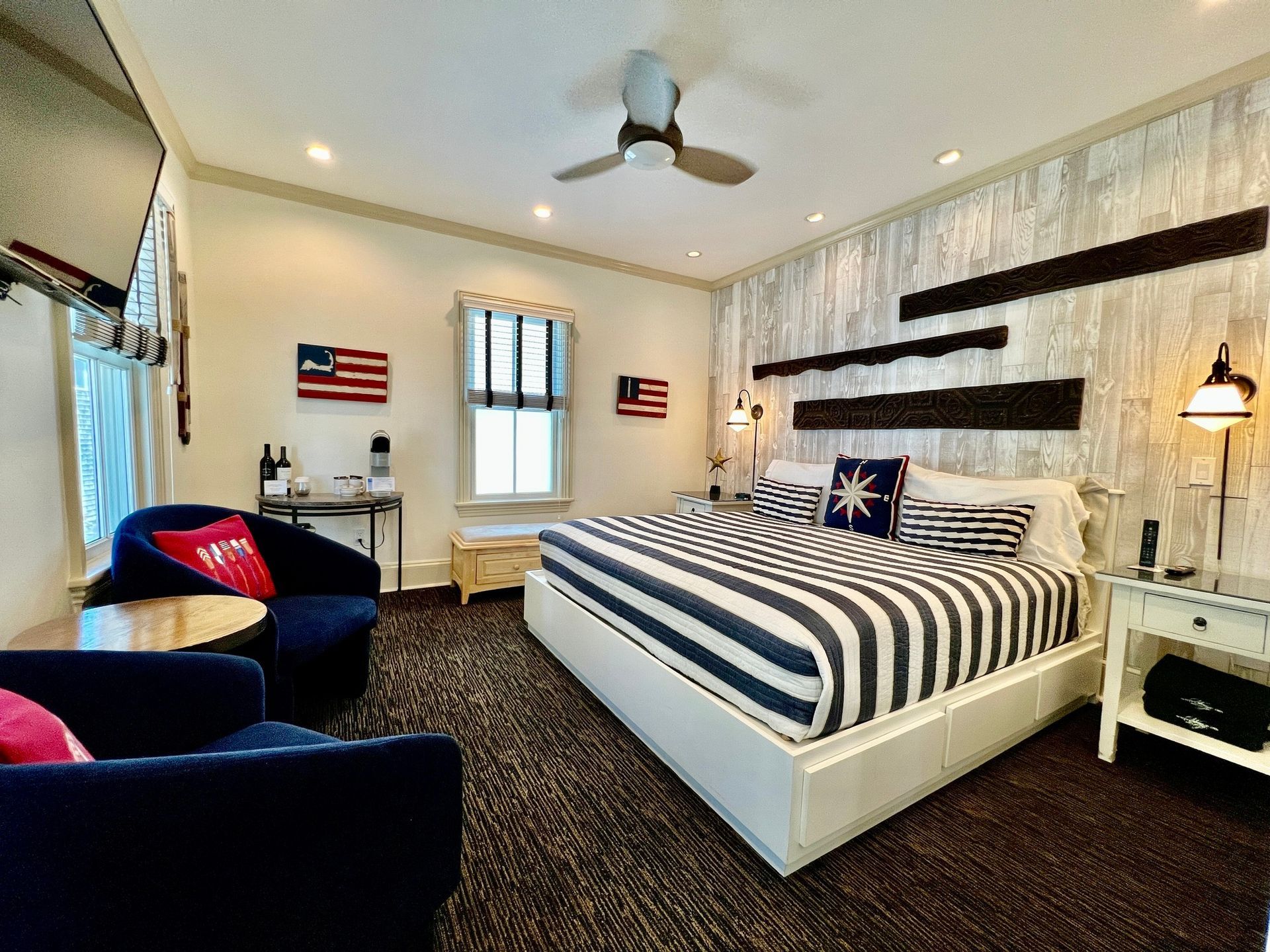 Interior room picture with large king bed sitting area and 3 windows.