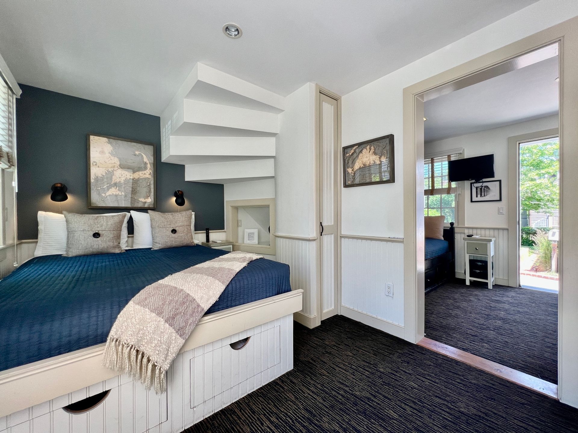 A bedroom with a bed and stairs leading up to the second floor.