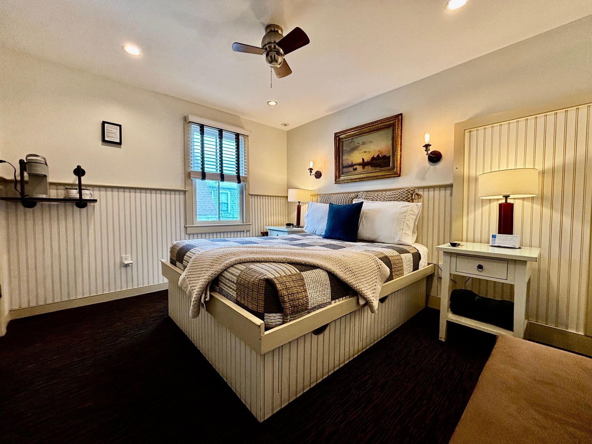 A bedroom with a queen size bed and a ceiling fan.