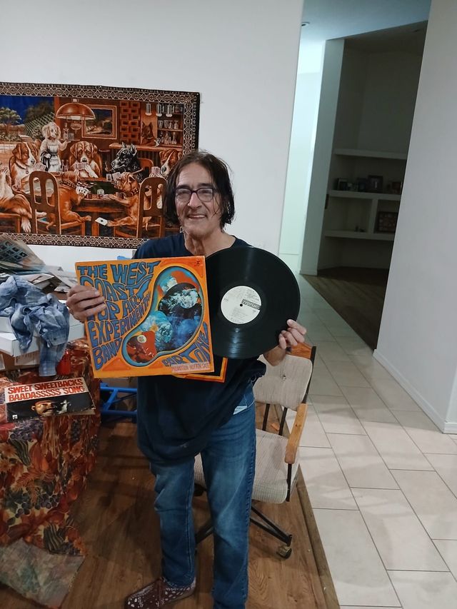 Man holding a West Coast Pop Art Experimental Band LP and its white-label promo record