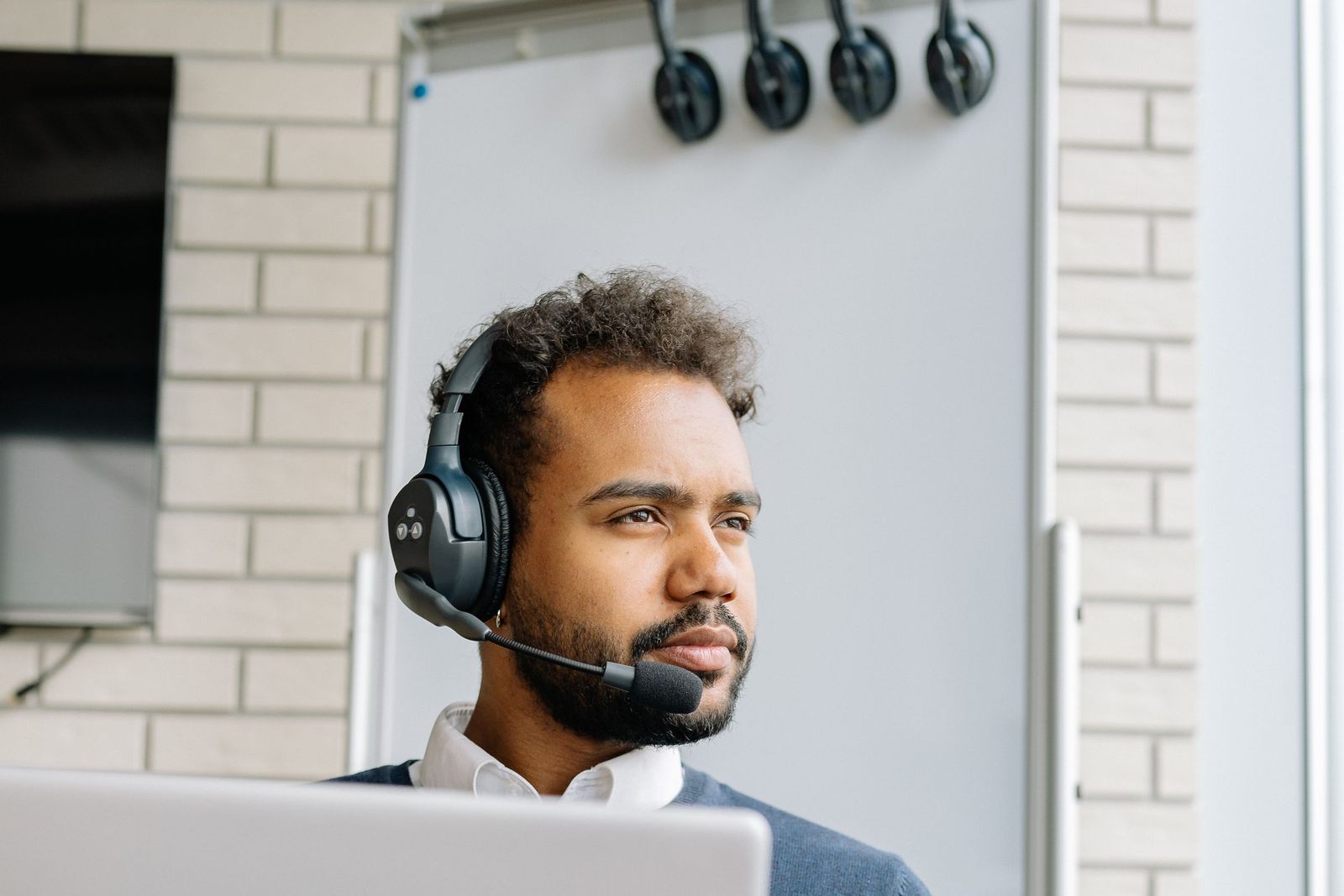 Professional wearing a headset on a laptop call in a modern office