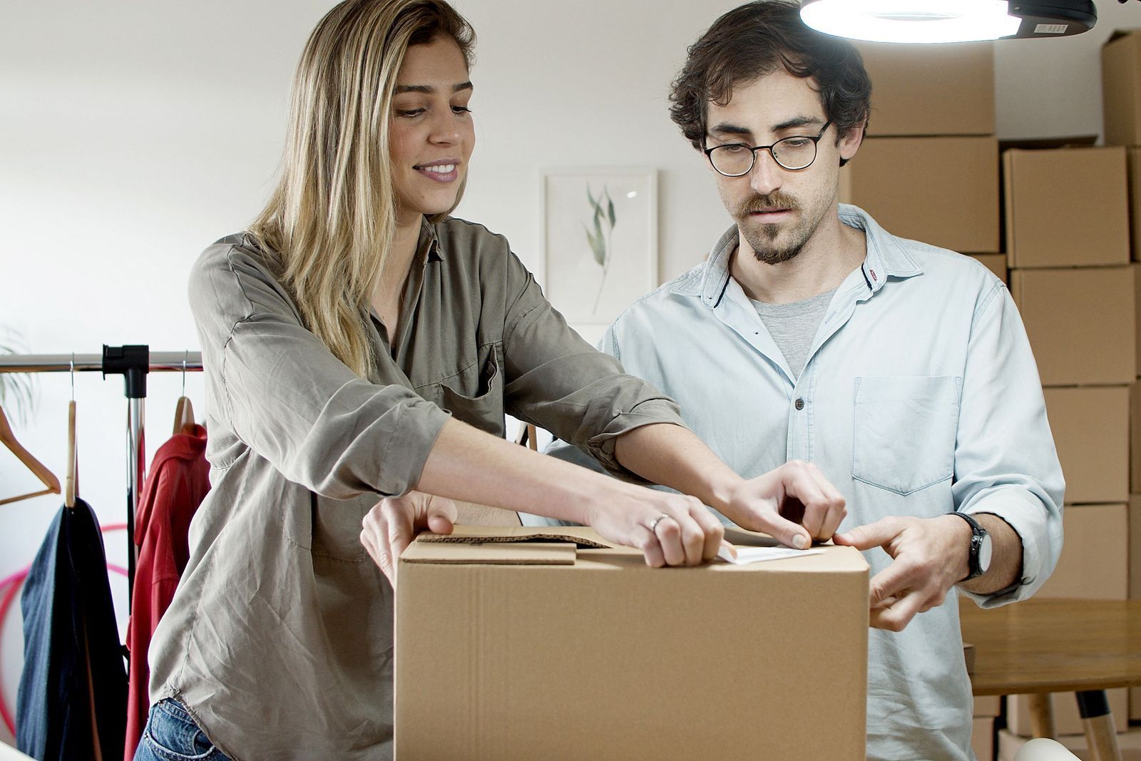 Two colleagues packing and labelling boxes ahead of an office move