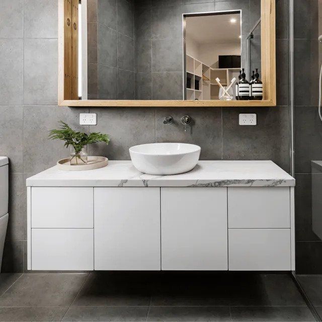Modern bathroom vanity with round sink, wood-framed mirror, and gray tiled walls