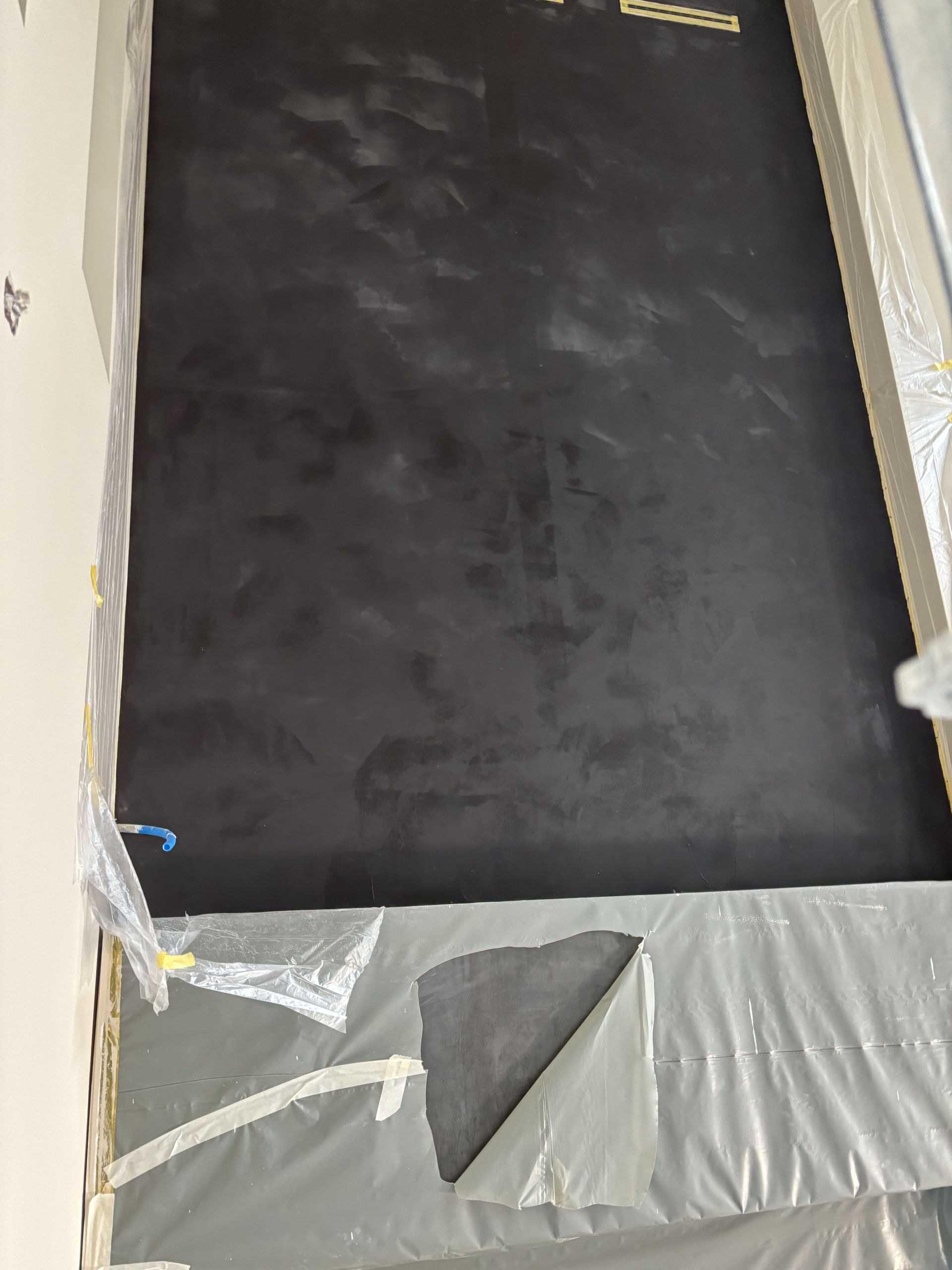Panneau mural noir avec revêtement plastique gris en bas et ruban adhésif sur les bords
