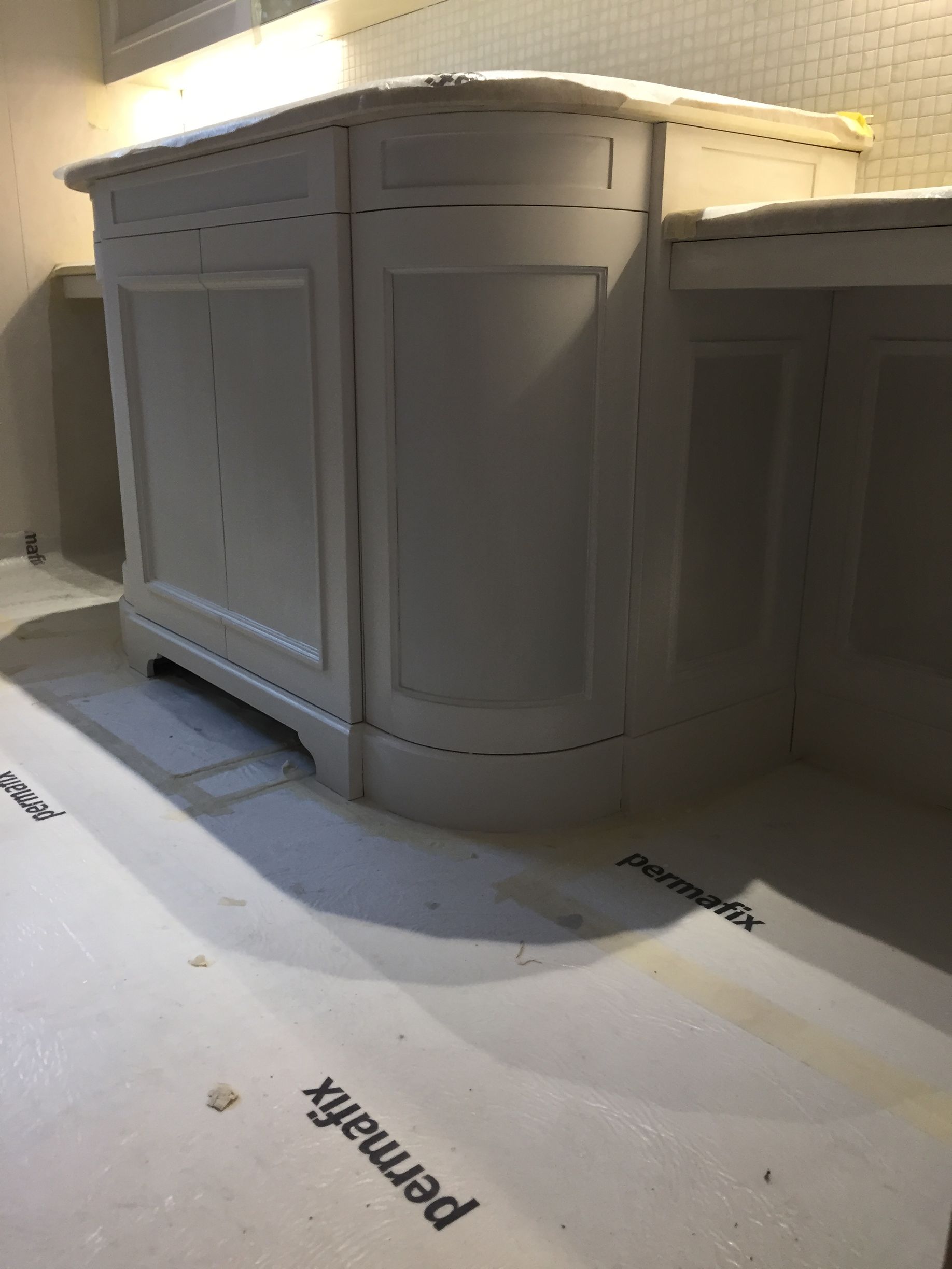 Armoire encastrée blanche avec portes à panneaux et angles arrondis dans une pièce recouverte de moquette