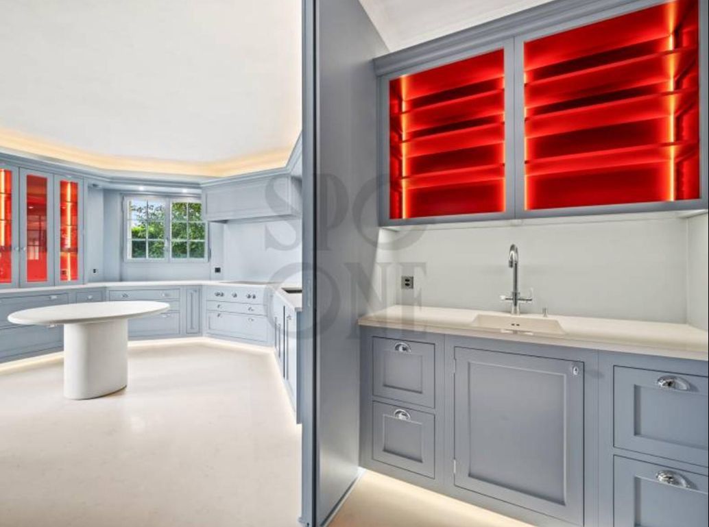 Cuisine blanche lumineuse avec volets rouges et meuble sous-évier au premier plan