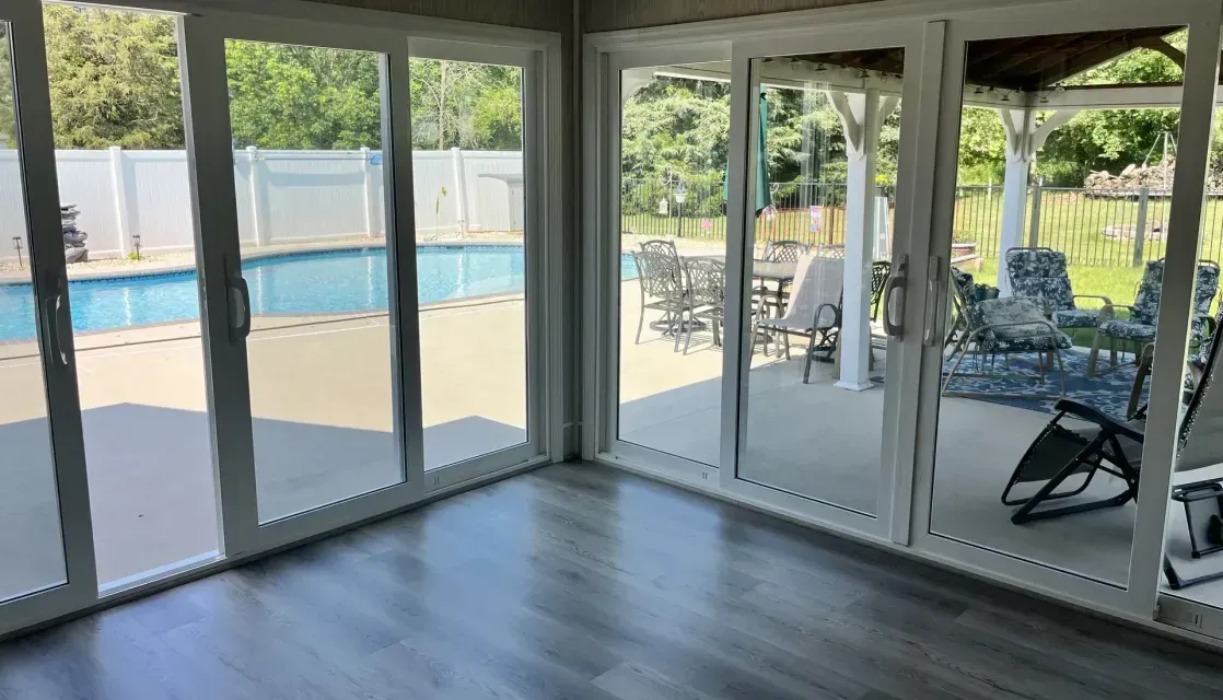 The corner of a room with all new floor-to-ceiling glass windows and doors. 