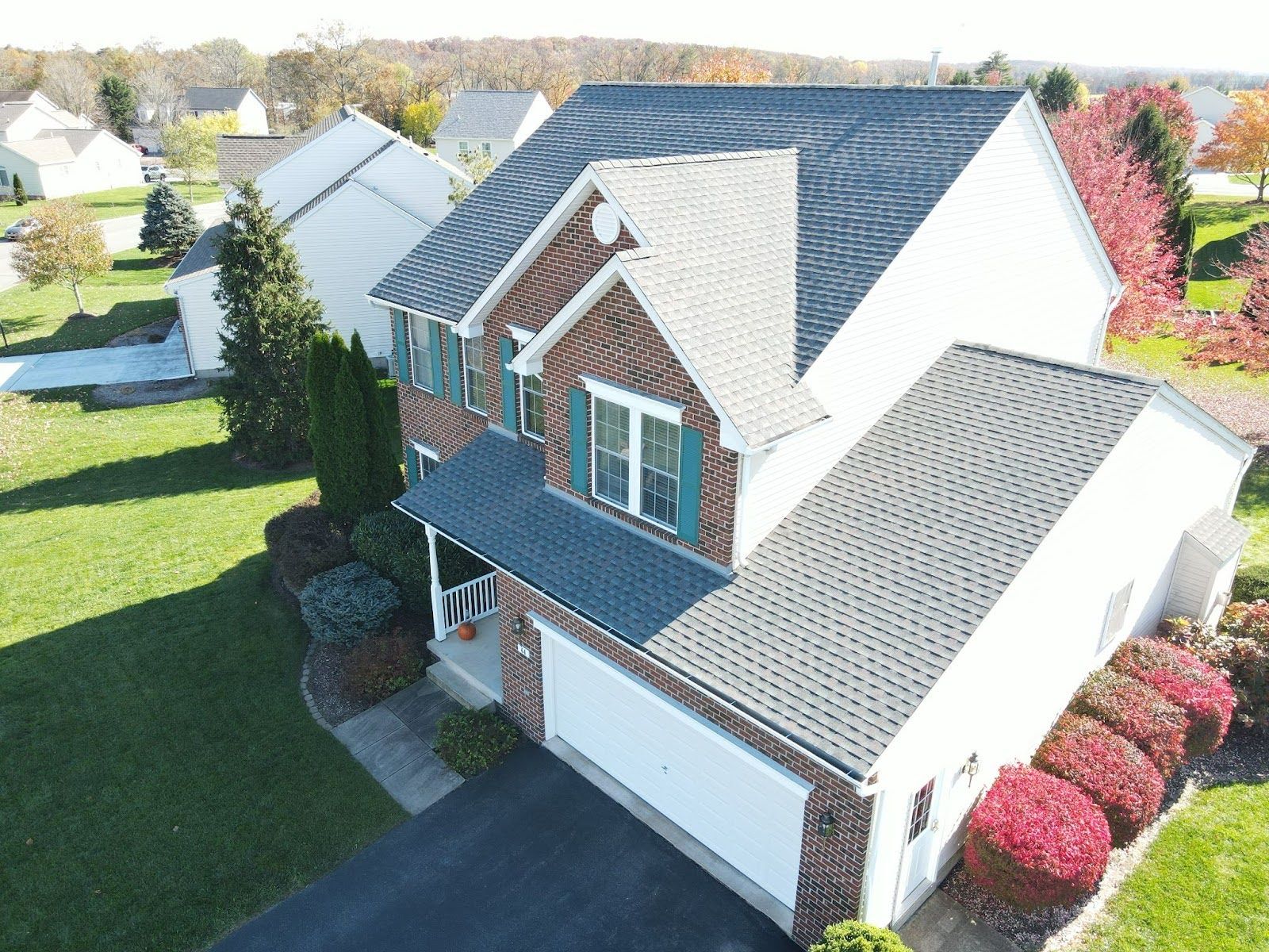 An aerial view of a brick house with a new roof