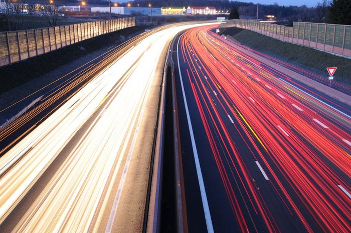 a long exposure photo of a highway at night