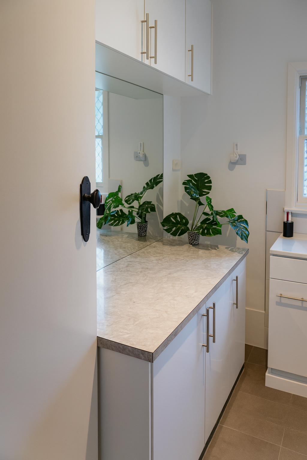 A Laundry Room With Black Cabinets, a Washer and Dryer, and a Window — JKD Pest & Carpentry In Wellington, NSW