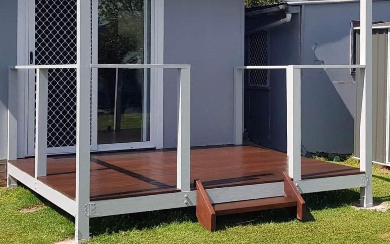 A Wooden Deck With a Sliding Glass Door Leading to a Dining Room — JKD Pest & Carpentry In Wellington, NSW