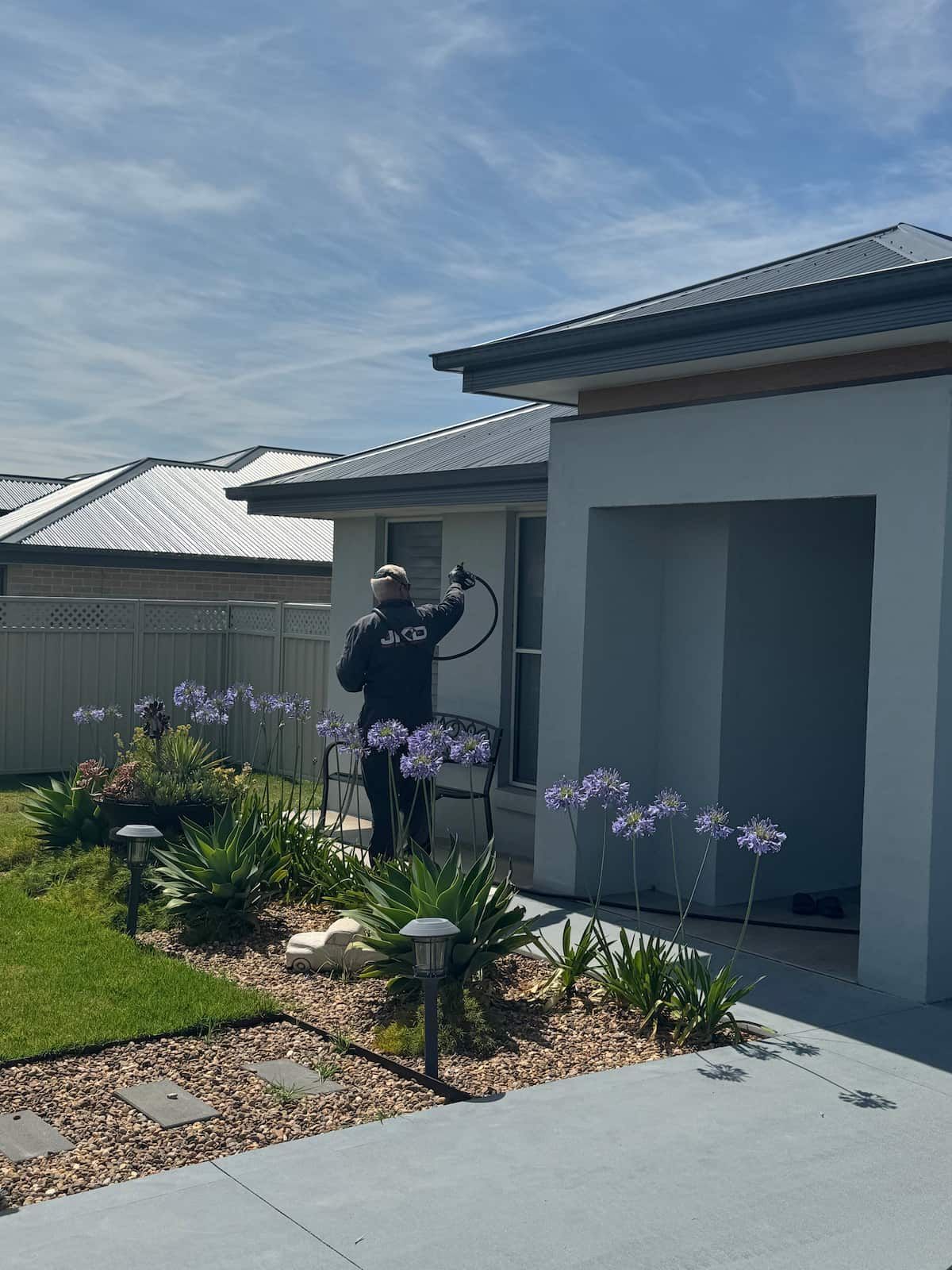A Man is Installing a Wooden Deck With a Drill — JKD Pest & Carpentry In Dubbo, NSW