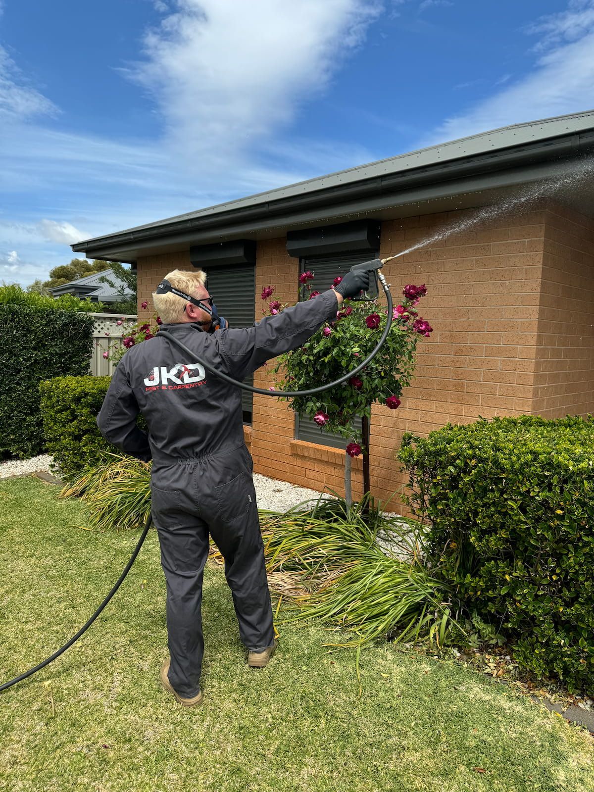 A Man is Measuring a Doorway With a Tape Measure — JKD Pest & Carpentry In Wellington, NSW