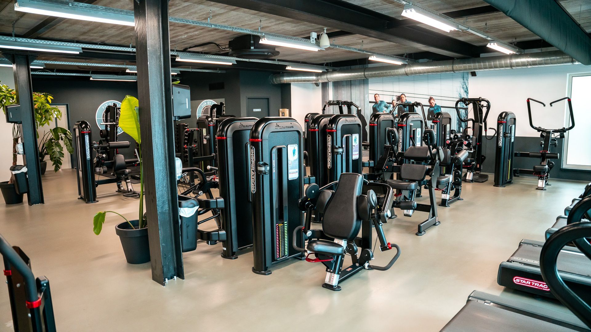 Een sportschool vol met veel oefenballen en dumbbells.