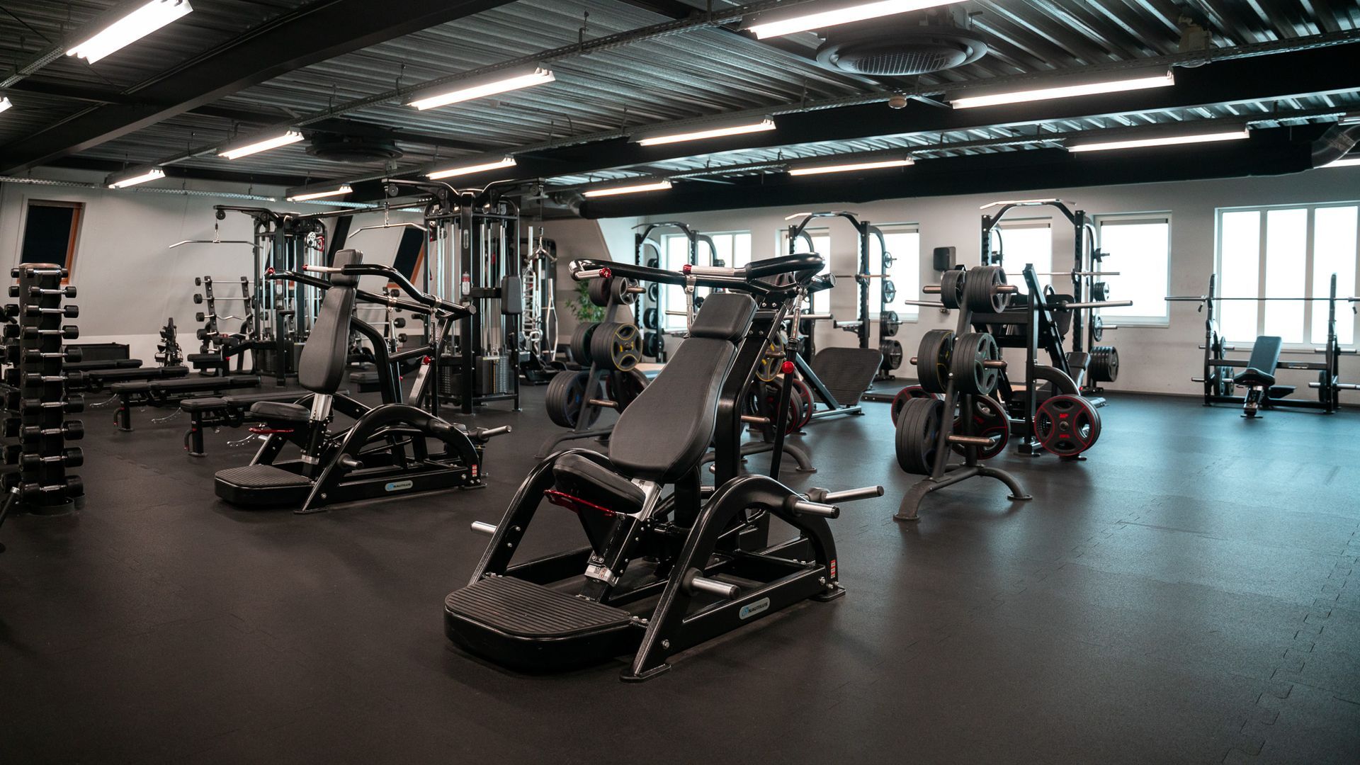 In een sportschool staat een rij loopbanden opgesteld.