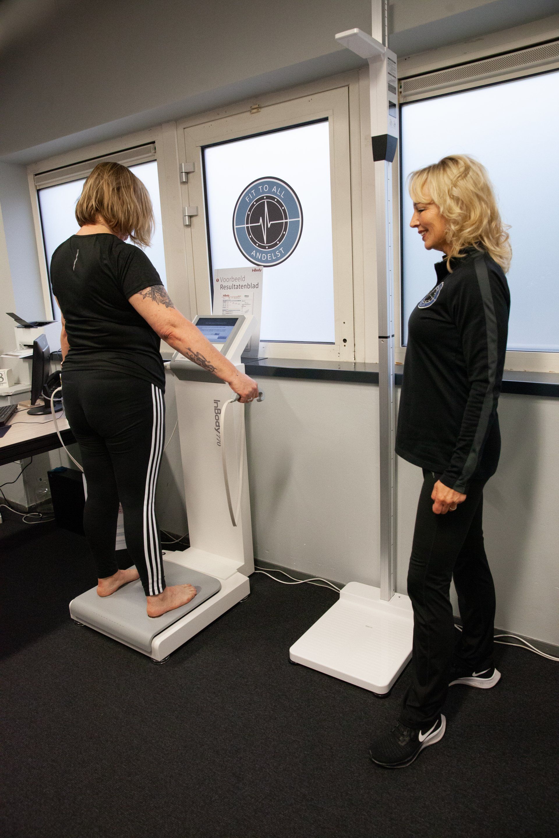 Twee vrouwen staan naast elkaar voor een machine.