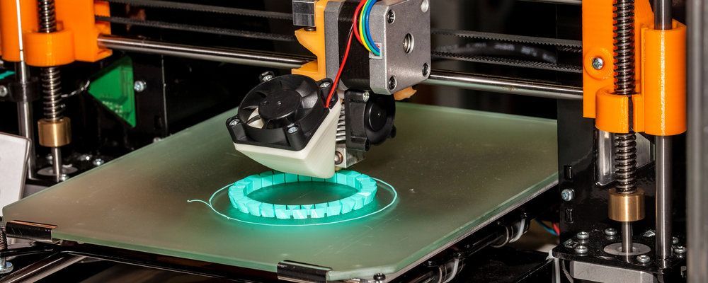 A close up of a 3d printer printing a bracelet.