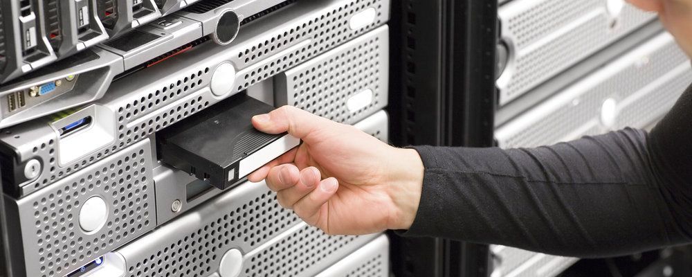 A person is inserting a hard drive into a server.