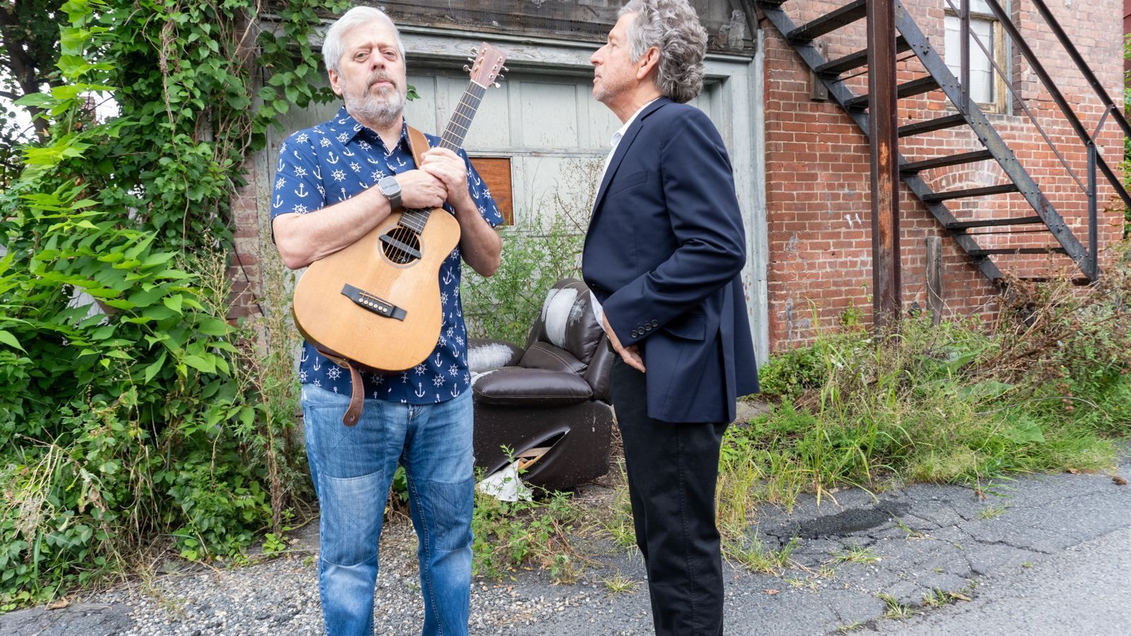Steve Alves and Kenny Butler facing each other, Kenny holding his guitar