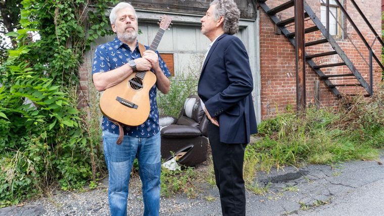 Steve Alves and Kenny Butler facing each other, Kenny holding his guitar