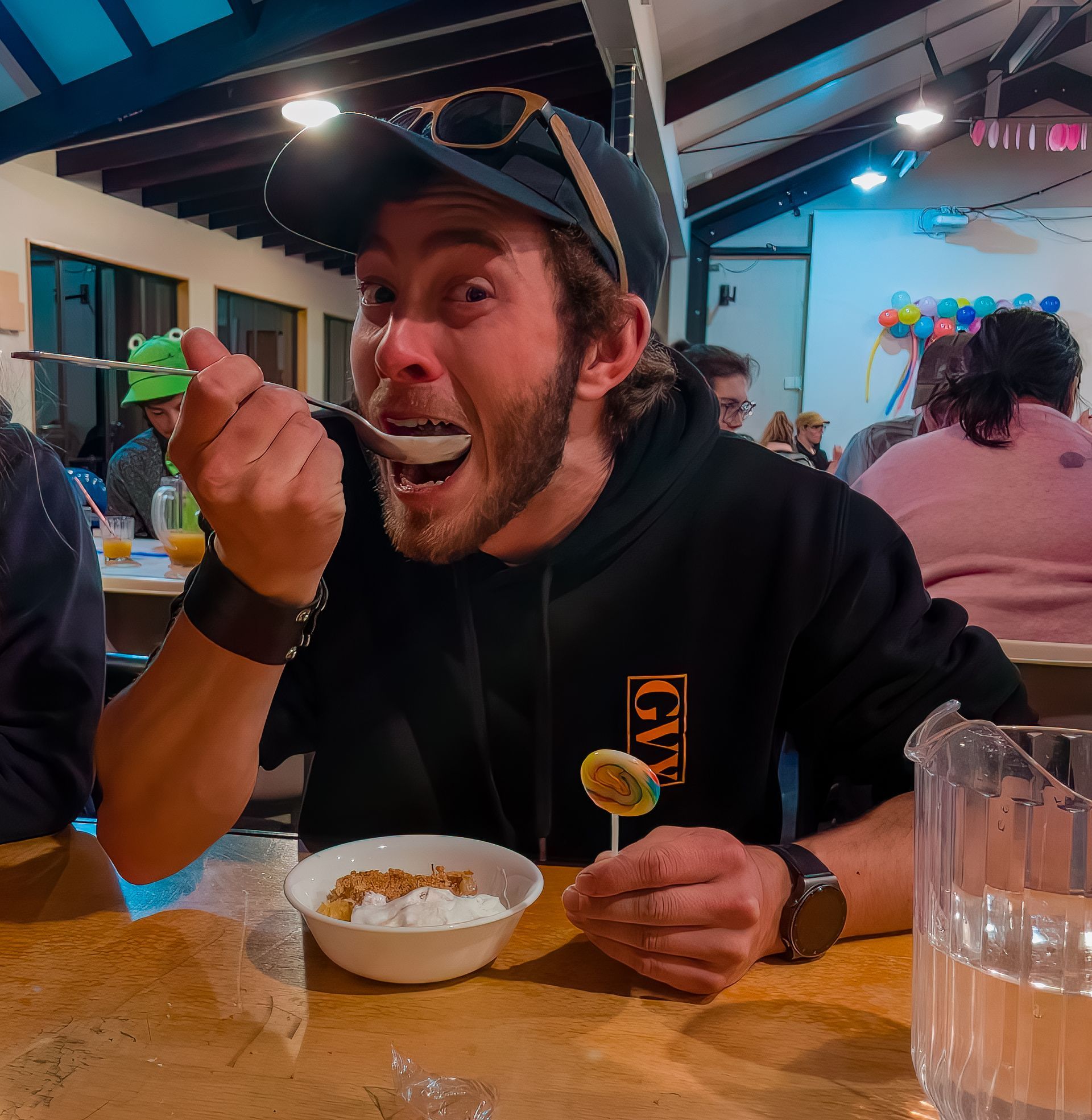 A man is sitting at a table eating food from a bowl