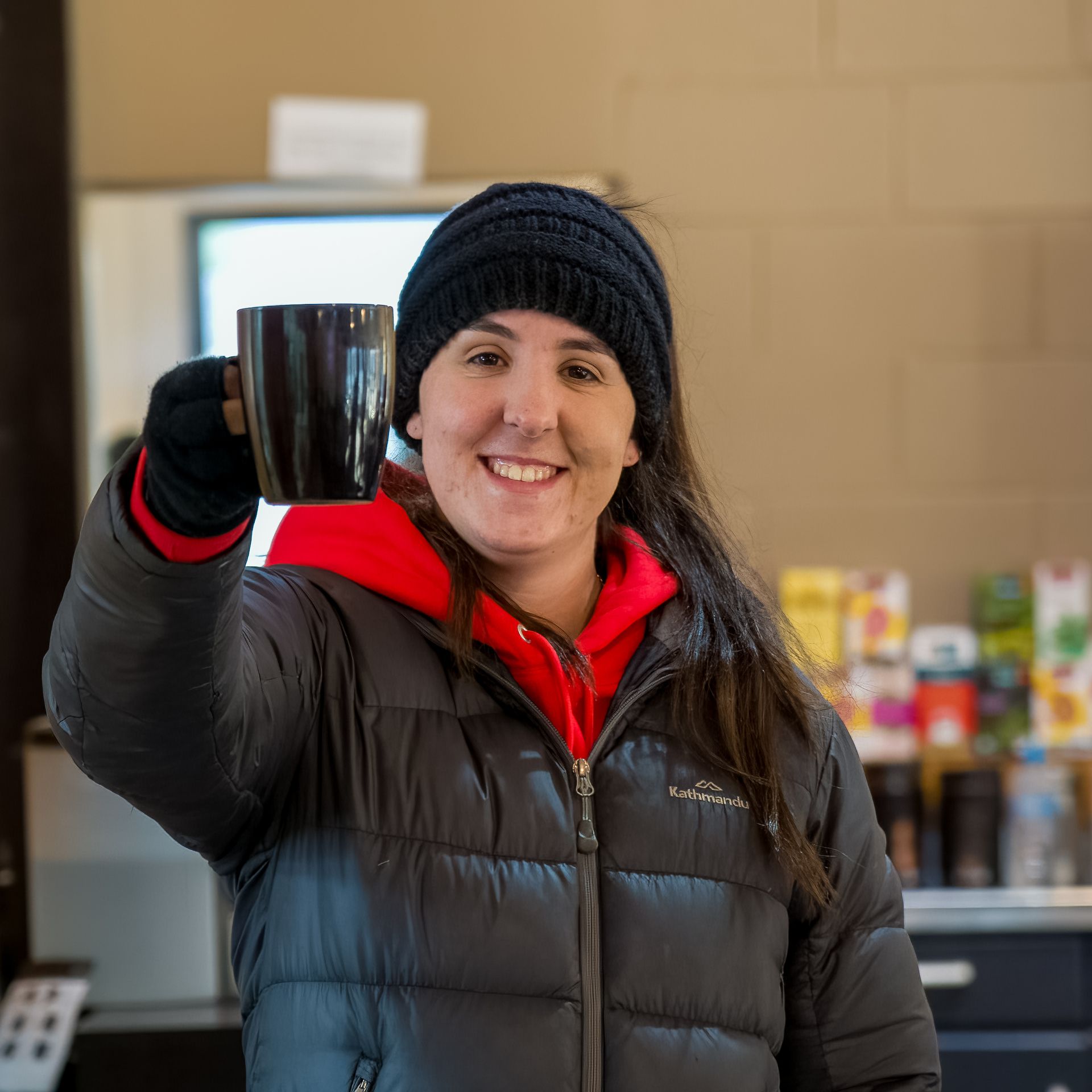 A woman is holding a cup of coffee in her hand.