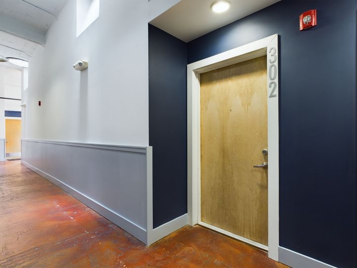 A hallway with a door that has the number 202 on it