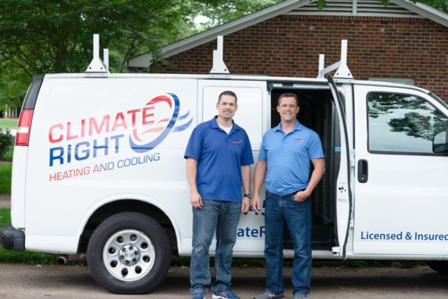 Two men are standing in front of a climate right van