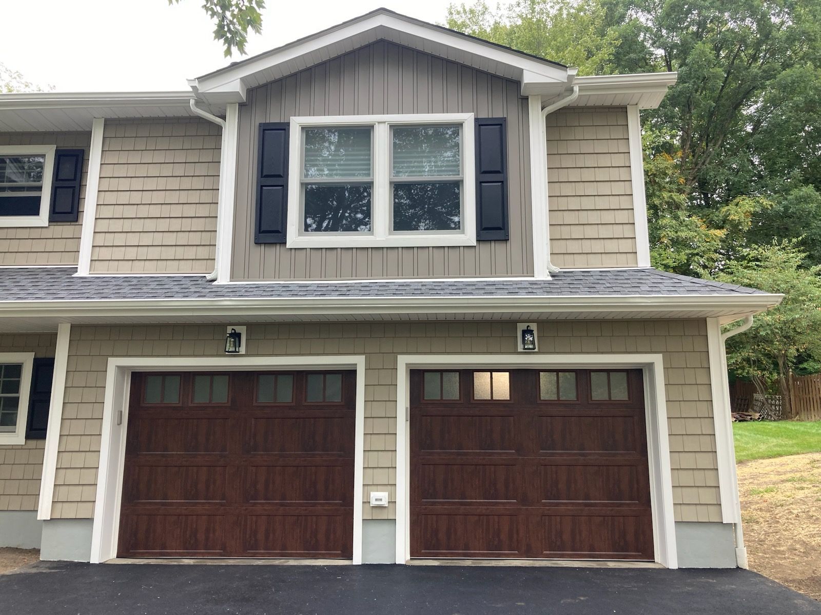 A house with two garage doors and a window with the letter g on it