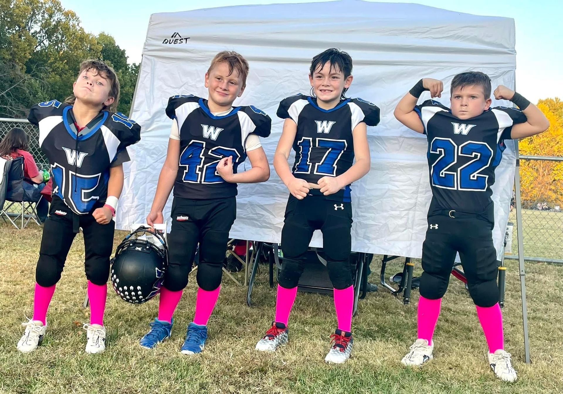 A group of young boys in football uniforms are posing for a picture.