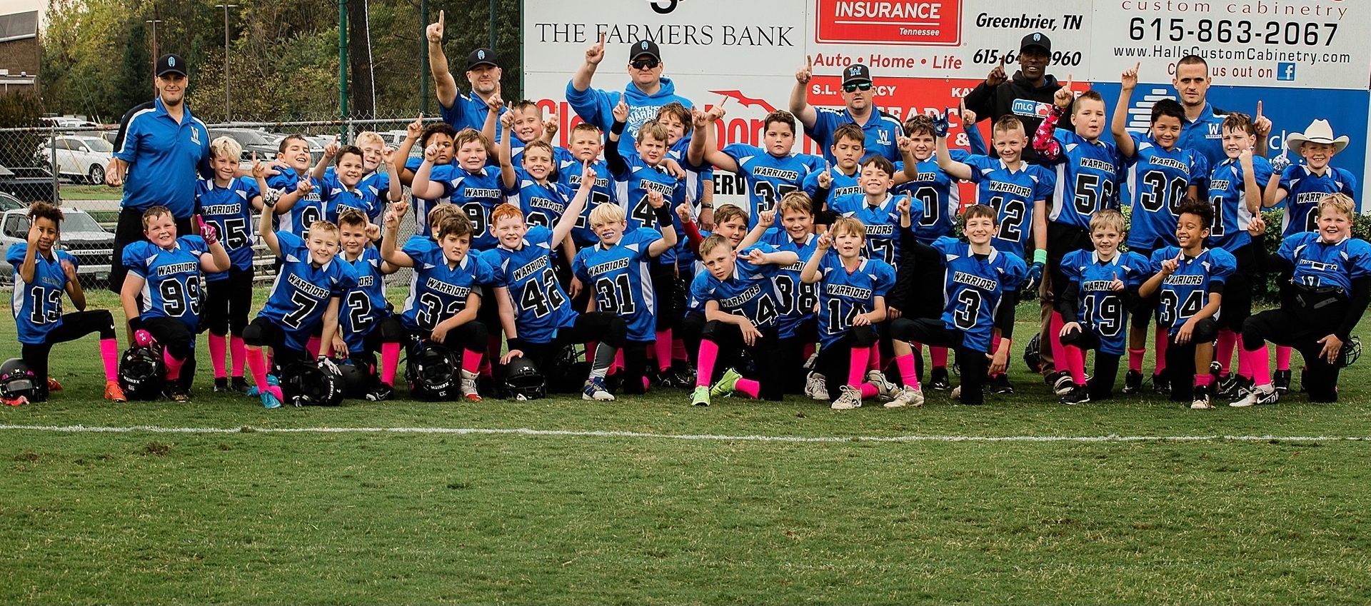 A group of young boys are posing for a picture on a football field.