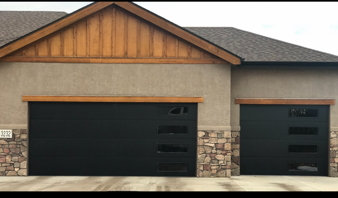 A man is working on a garage door in a garage.