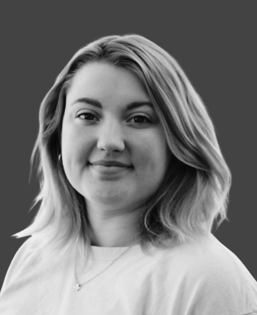 A black and white photo of a woman wearing a white shirt and a necklace.