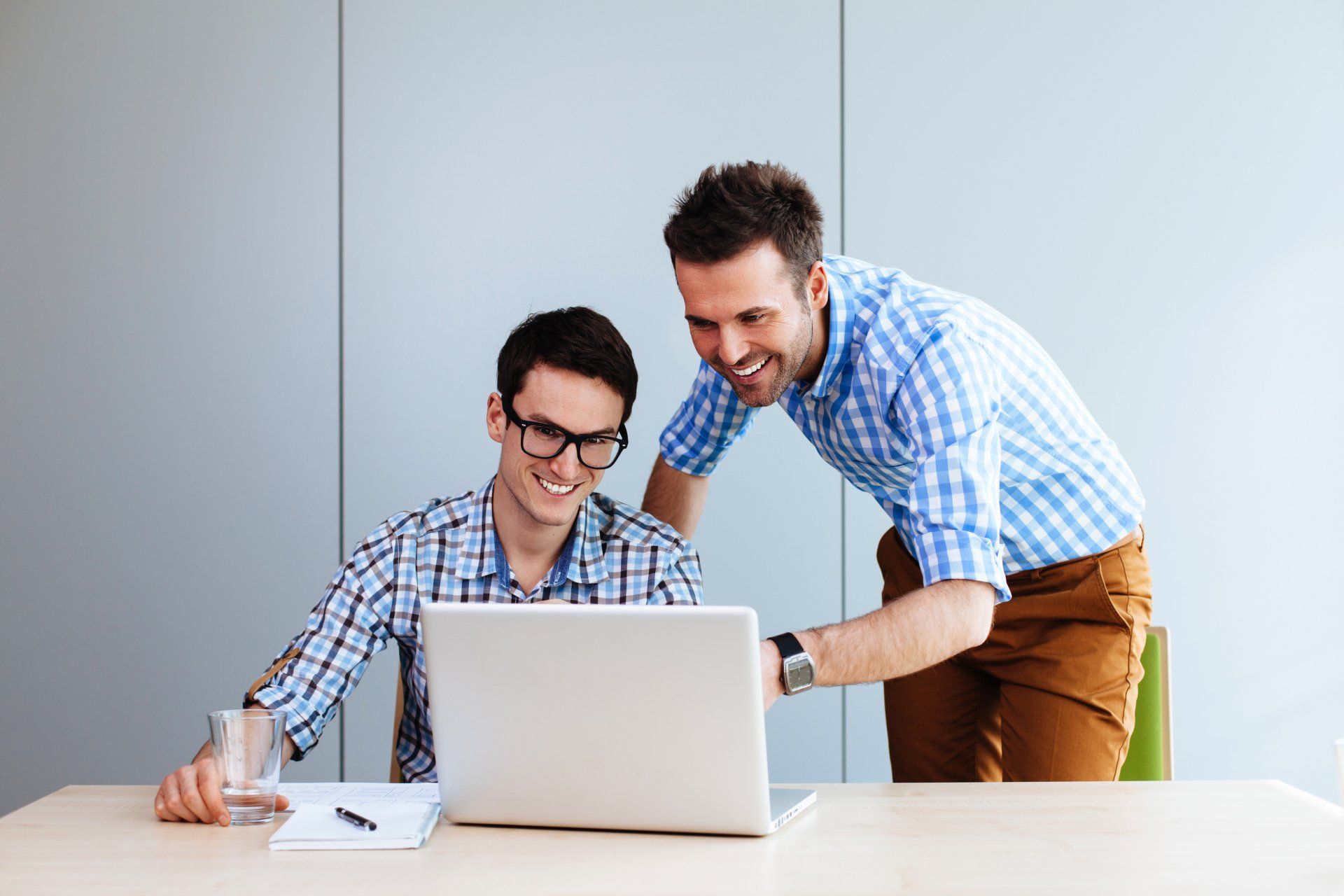 two mean pointing at a computer screen