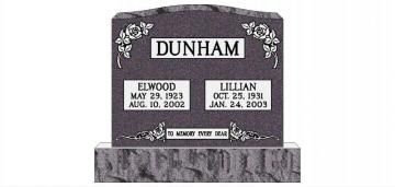 Black granite gravestone with floral carvings and the surname Dunham above two memorial plaques.