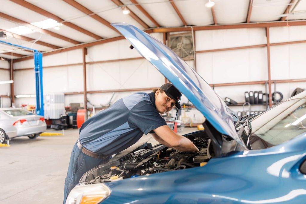 Mechanic working on a blue car engine | Stephen's Automotive