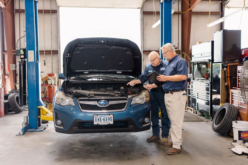 Examining a blue car's engine | Stephen's Automotive