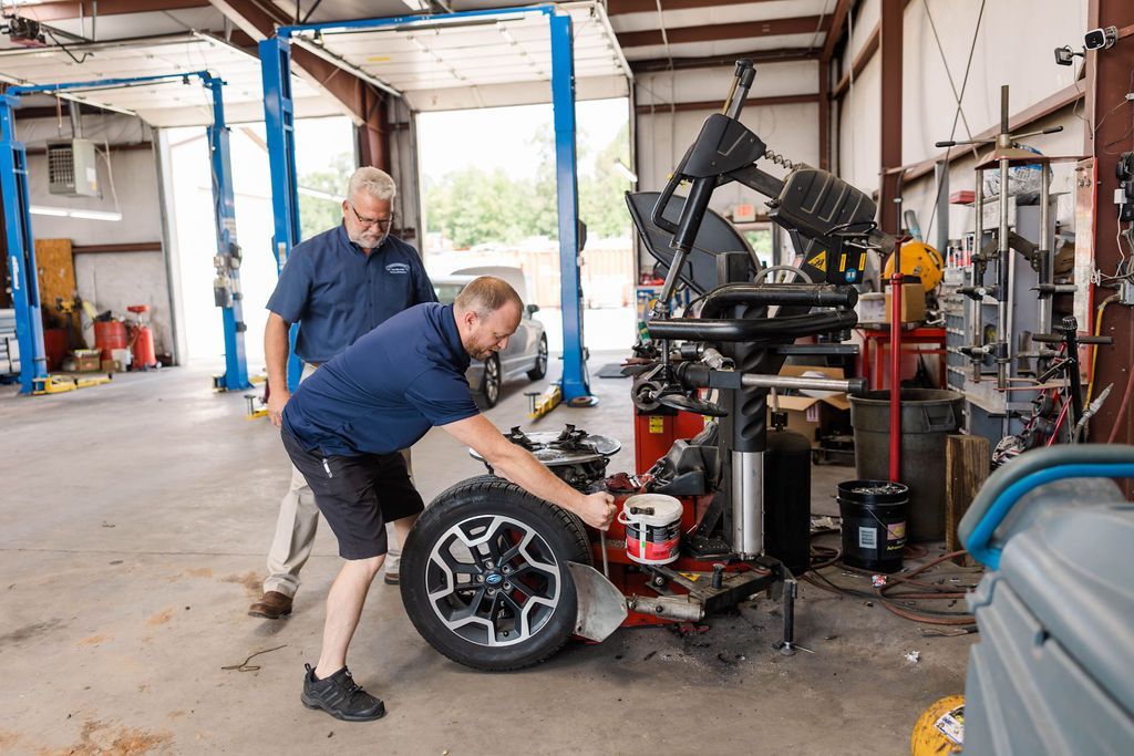 Mechanics work on a car tire with | Stephen's Automotive