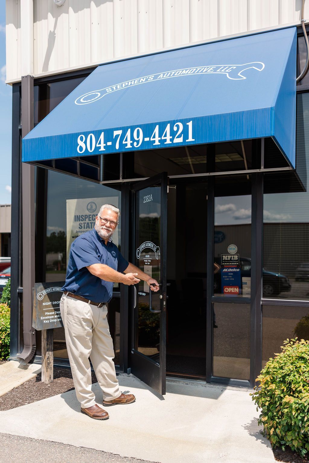 Owner pointing at door of the auto repair shop | Stephen's Automotive